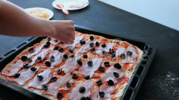 做饭准备披萨特写女人她的手把西红柿和酱汁和培根放在面团里视频的预览图