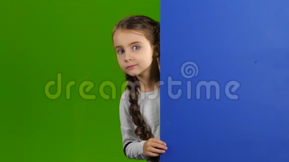 孩子从蓝色的木板后面往外看竖起大拇指绿色屏幕视频的预览图