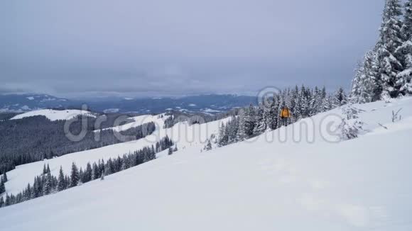 一个游客走过山上的雪视频的预览图