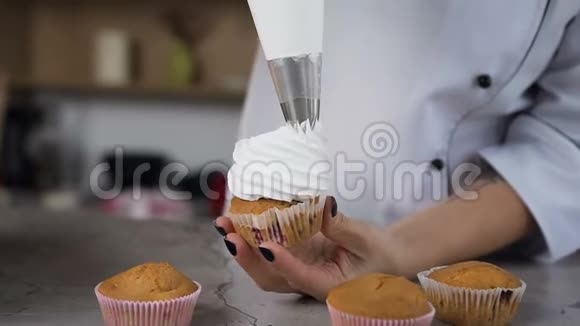 厨师用糕点袋在蛋糕上涂上奶油的特写镜头视频的预览图