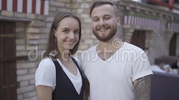 一对迷人的年轻欧裔夫妇笑着用手做心形的肖像动作缓慢视频的预览图