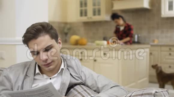 小伙子看着文件在厨房里找女朋友视频的预览图
