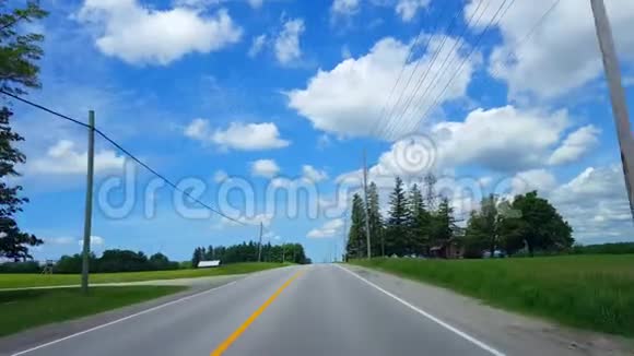 在明亮的夏日驾驶农村沿着美丽的阳光路的司机视角视频的预览图