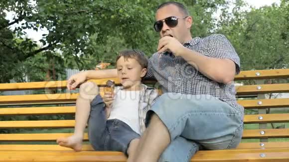 父亲和儿子坐在长凳上视频的预览图