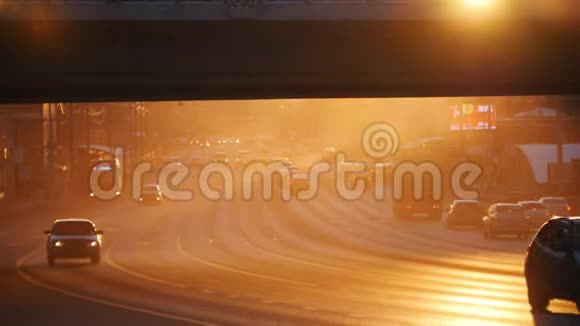 一个大城市汽车在桥下的道路上行驶日落视频的预览图