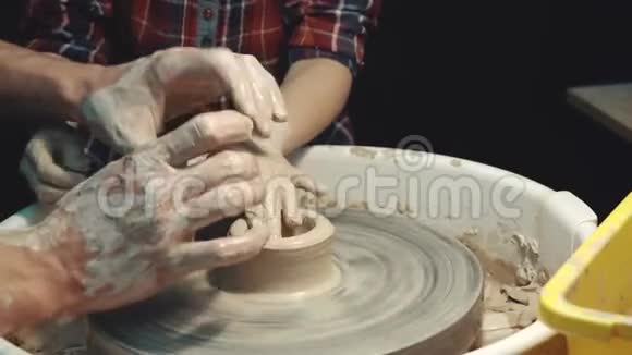 陶艺大师班老师让孩子在陶工的轮子上粘土视频的预览图