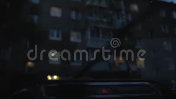 在挡风玻璃上工作汽车雨刷从车上看车在一栋公寓楼的院子里4慢视频的预览图