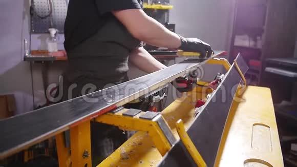 滑雪板保养维修理念车间工人正在打蜡和修理滑雪板和滑雪板视频的预览图