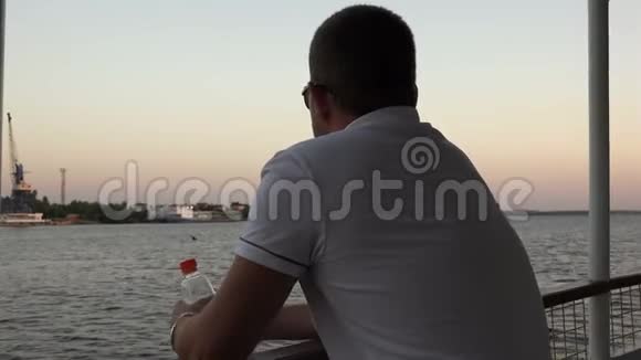 一个年轻人站在汽车船甲板上喝柠檬水视频的预览图