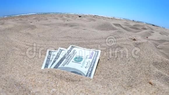 钱娃娃一半被沙子覆盖在海滩特写视频的预览图