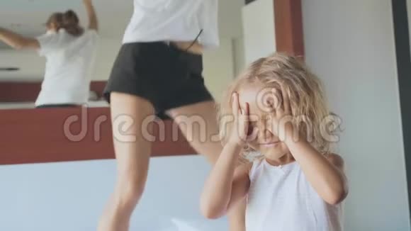 兴奋的小孩有一个多动症的母亲在床上跳起来的背景视频的预览图