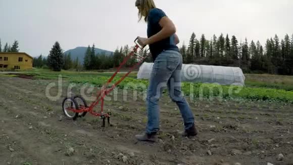 在农场使用农业设备的妇女视频的预览图