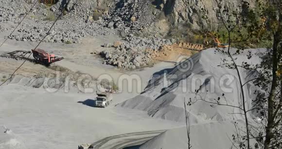 大型工业自卸汽车在采石场采矿开采石料中运输货物视频的预览图