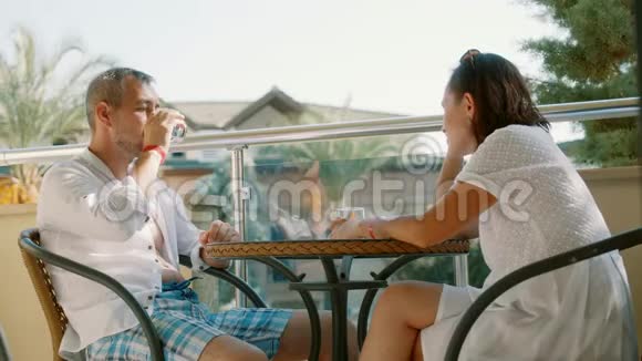 一对相爱的夫妇坐在玻璃桌旁恋爱关系假日浪漫视频的预览图