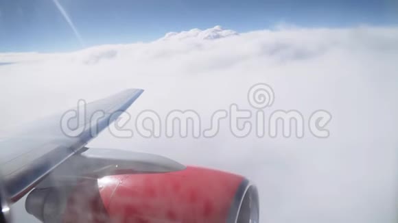 从舷窗到云层的景色从飞机的窗口看飞机的机翼与喷气发动机视频的预览图