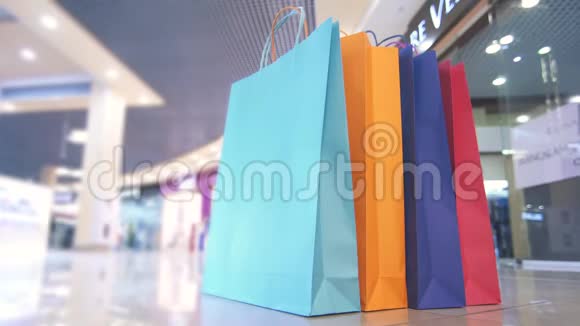 彩色购物袋在商场背景下经过的人时间流逝视频的预览图