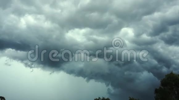 强风摇树风暴云中闪电的景象视频的预览图