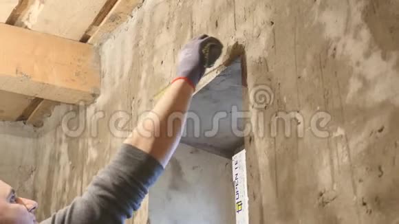 一位印象深刻的建筑工人站在工地上测量墙壁视频的预览图