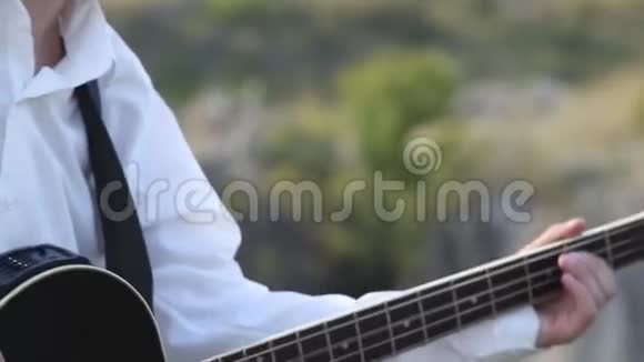 低音吉他手在岩石高原弹吉他视频的预览图