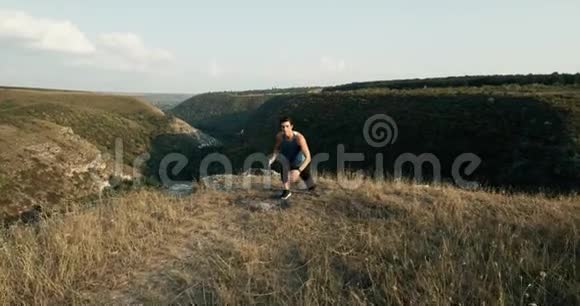 健康的年轻的英俊的有吸引力的白人在山顶上热身晨跑红色史诗视频的预览图