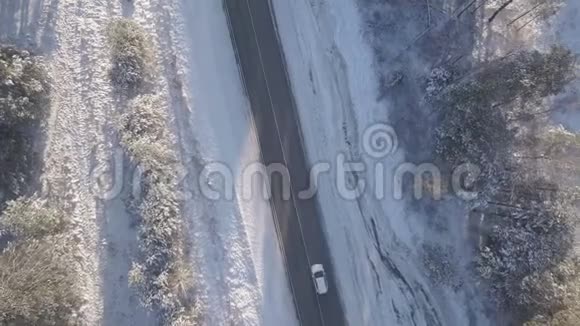 汽车在冬天的道路上行驶上面覆盖着白雪的树木视频的预览图