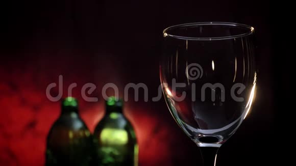 在玻璃杯中倒入红酒两瓶和深红色背景浪漫的气氛高质量的视频视频的预览图