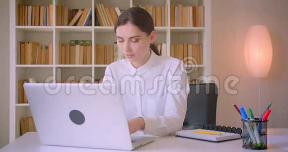 年轻迷人的白种人女商人的特写镜头她用笔记本电脑看着镜头开心地笑着视频的预览图