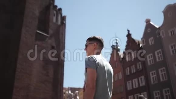 一个戴墨镜的人一个游客走在欧洲的街道上视频的预览图