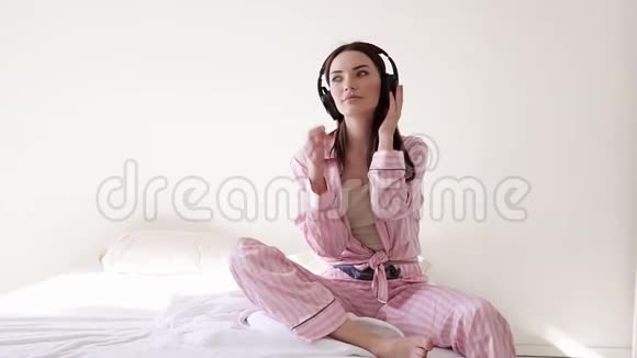 穿着睡衣的女人从耳机里跳舞视频的预览图