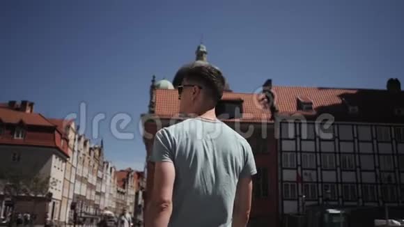 一个戴墨镜的人一个游客走在欧洲的街道上视频的预览图