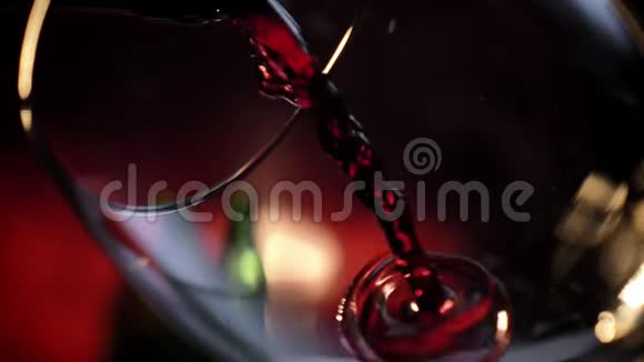 将红酒倒入酒杯的近距离拍摄深红色背景浪漫气氛高质量的视频约会视频的预览图