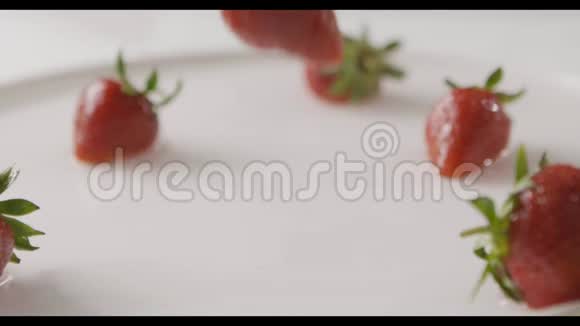 成熟的红色草莓果实落入一盘水的中心溅起水花和水滴一些浆果视频的预览图