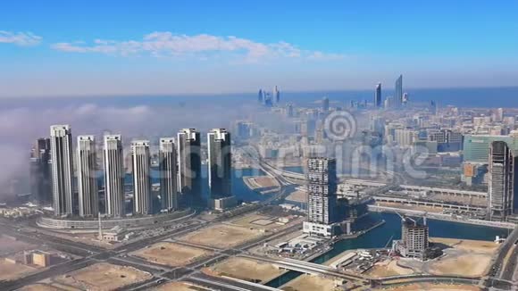 早上可鸟瞰阿布扎比的城市天际线著名的塔楼和被雾云包围的摩天大楼视频的预览图