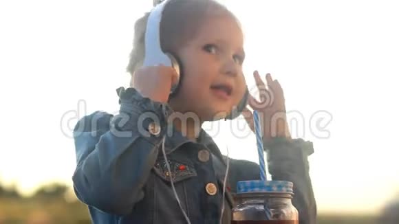 戴耳机的小女孩听音乐喝鸡尾酒果汁冰沙视频的预览图