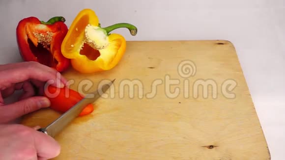 在木板上用刀切制橘红辣椒视频的预览图