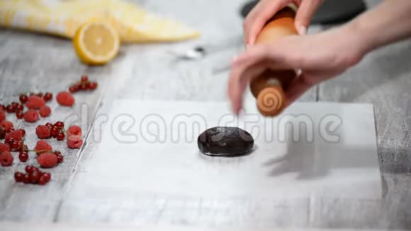 把巧克力面团滚到烤羊皮层上做巧克力层蛋糕视频的预览图