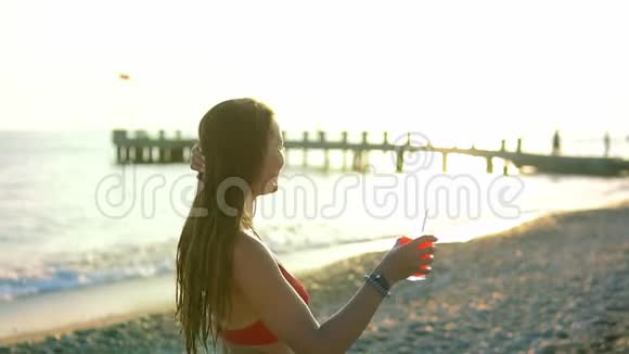 吸引人的年轻游客在海边或海洋附近的海滩喝新鲜鸡尾酒视频的预览图
