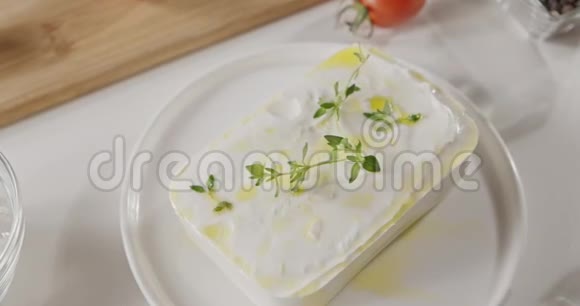 缓慢的圆形运动顶部的特写软奶酪奶酪滴橄榄油和一枝百里香顶部视图视频的预览图