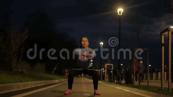 女孩在路堤上用橡皮筋做运动2运动员独自一人在夜城火车视频的预览图