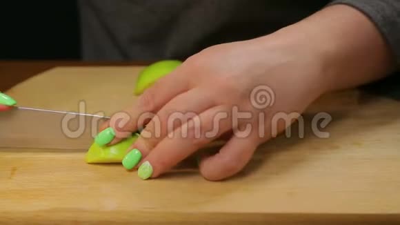 一个女人用刀子把一个绿色的苹果切成小块视频的预览图