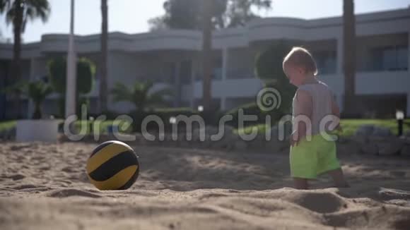 小男孩在海滩上缓慢地玩球视频的预览图