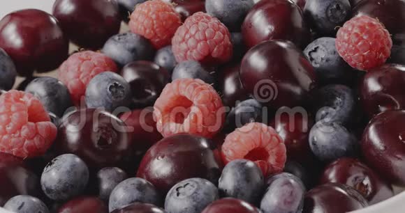 牛奶酸奶有一个溅在甜红水果覆盆子樱桃蓝莓特写慢动作视频混合视频的预览图