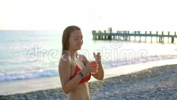 吸引人的年轻游客在海边或海洋附近的海滩喝新鲜鸡尾酒视频的预览图