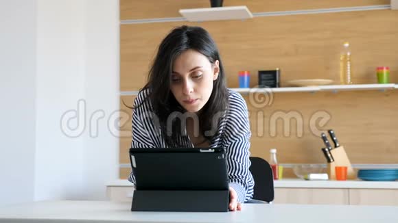 厨房里拿着数码电脑的女人视频的预览图