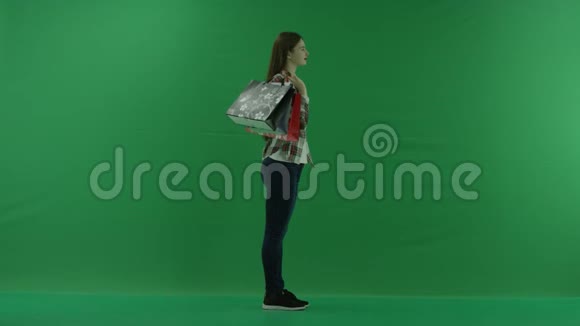 肩扛购物袋的女孩站在右边在绿色屏幕上微笑视频的预览图