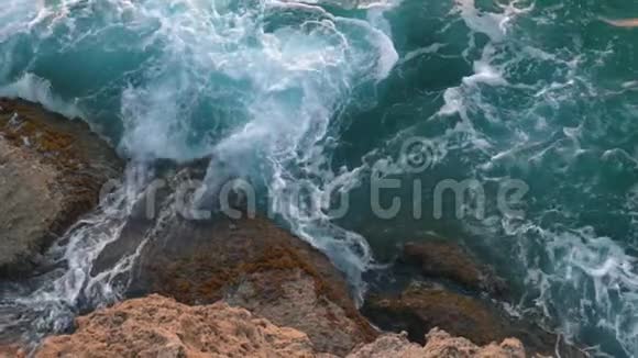 在海浪中巨大的蓝色波浪在岩石上破碎的鸟瞰图行动海洋要素视频的预览图