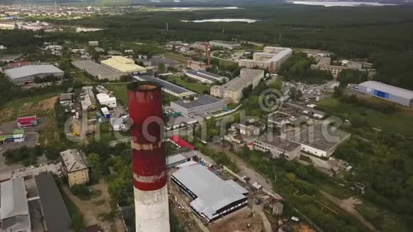工业区和被绿色森林包围的工厂大厦上方的高红白烟秆近距离视频的预览图