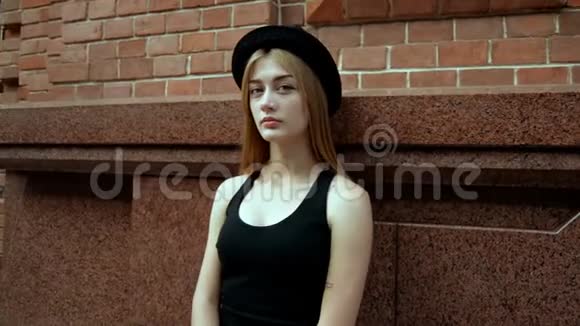 穿着黑色T恤和帽子的迷人少女视频的预览图