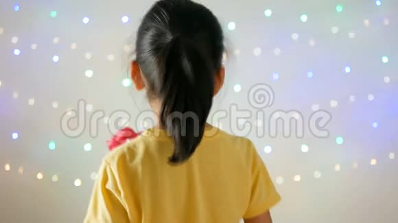 可爱的亚洲小女孩躲起来在闪闪发光的背景下送花束视频的预览图