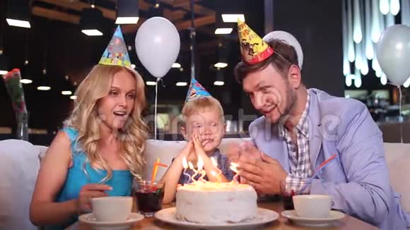 小男孩在生日蛋糕上吹蜡烛视频的预览图